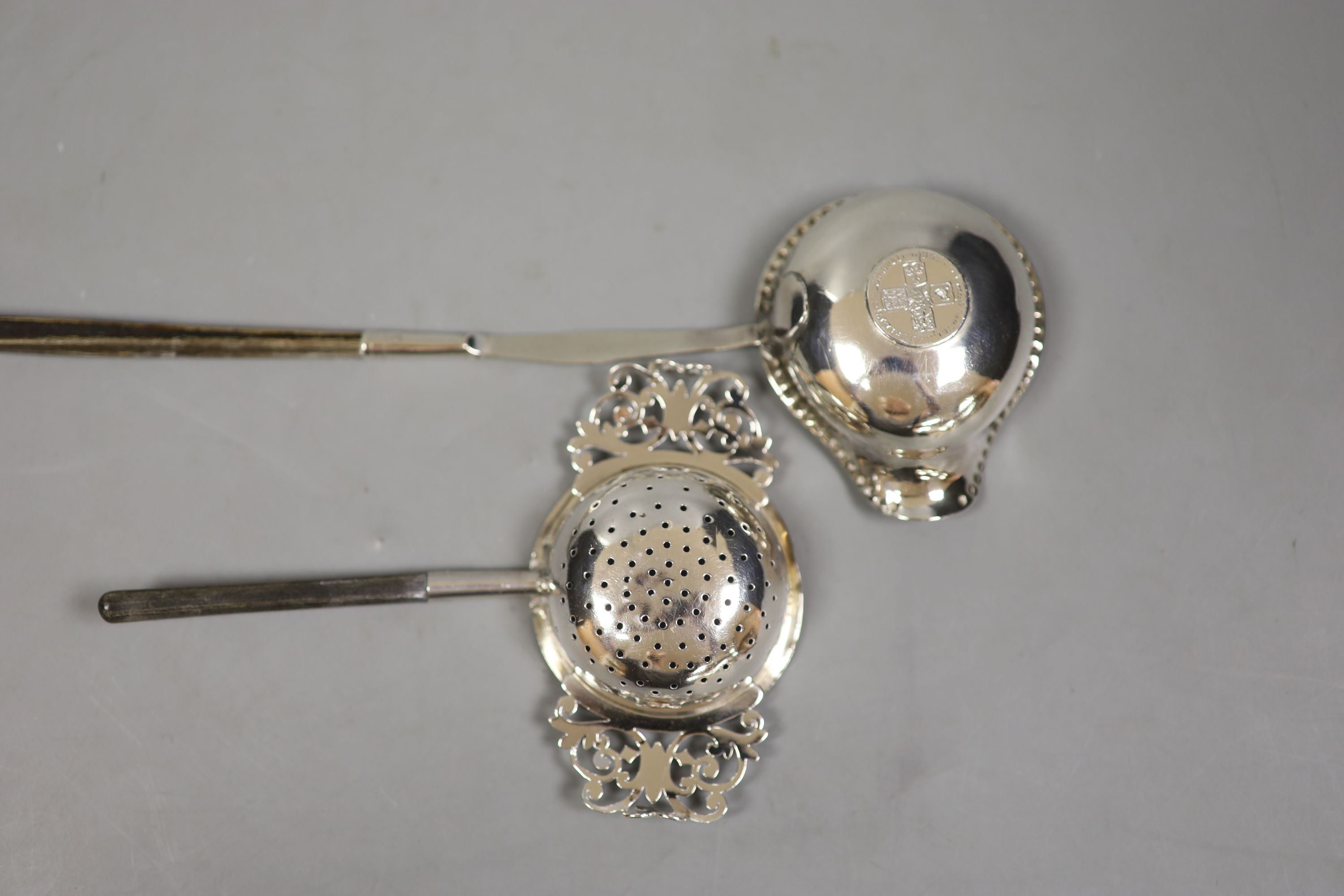 A straining ladle, Sheffield, 1909 by Harrison Brothers & George Howson, together with a coin set toddy ladle.